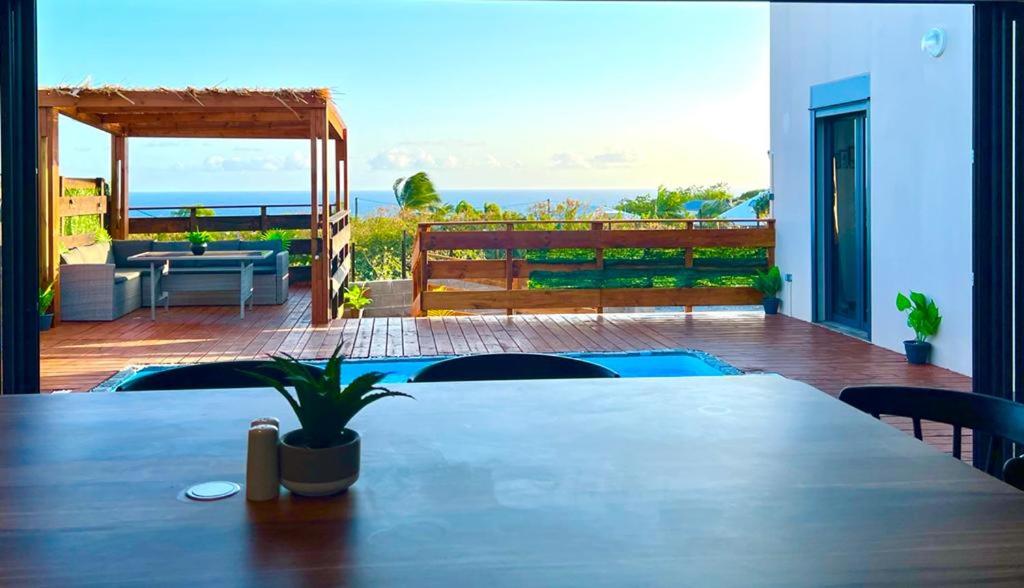 Vue depuis la salle à manger sur la terrasse, la piscine et l'horizon mer
